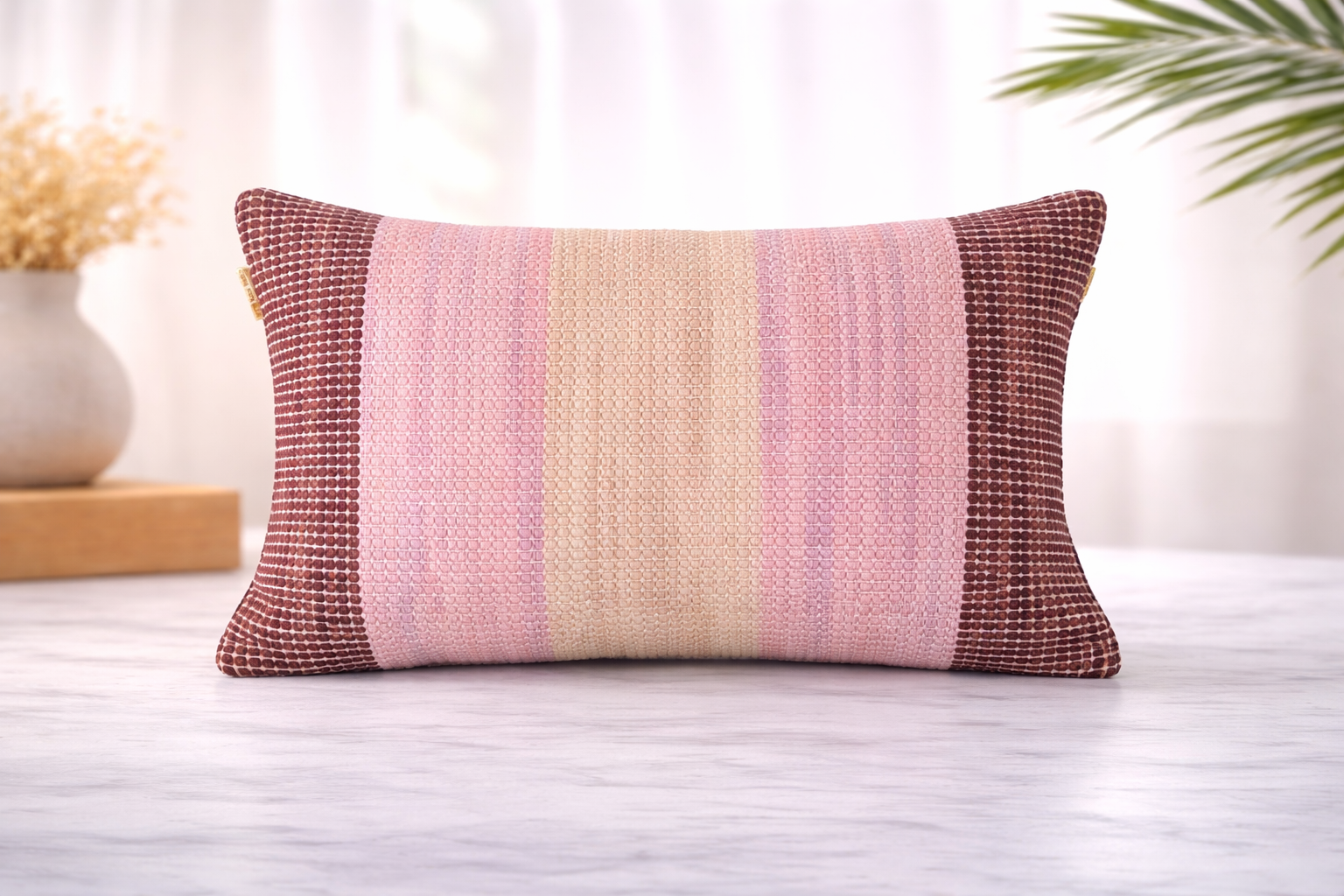 Woven lumbar pillow cover with a blush and cream ombré stripe center panel and deep burgundy woven border panels at each end