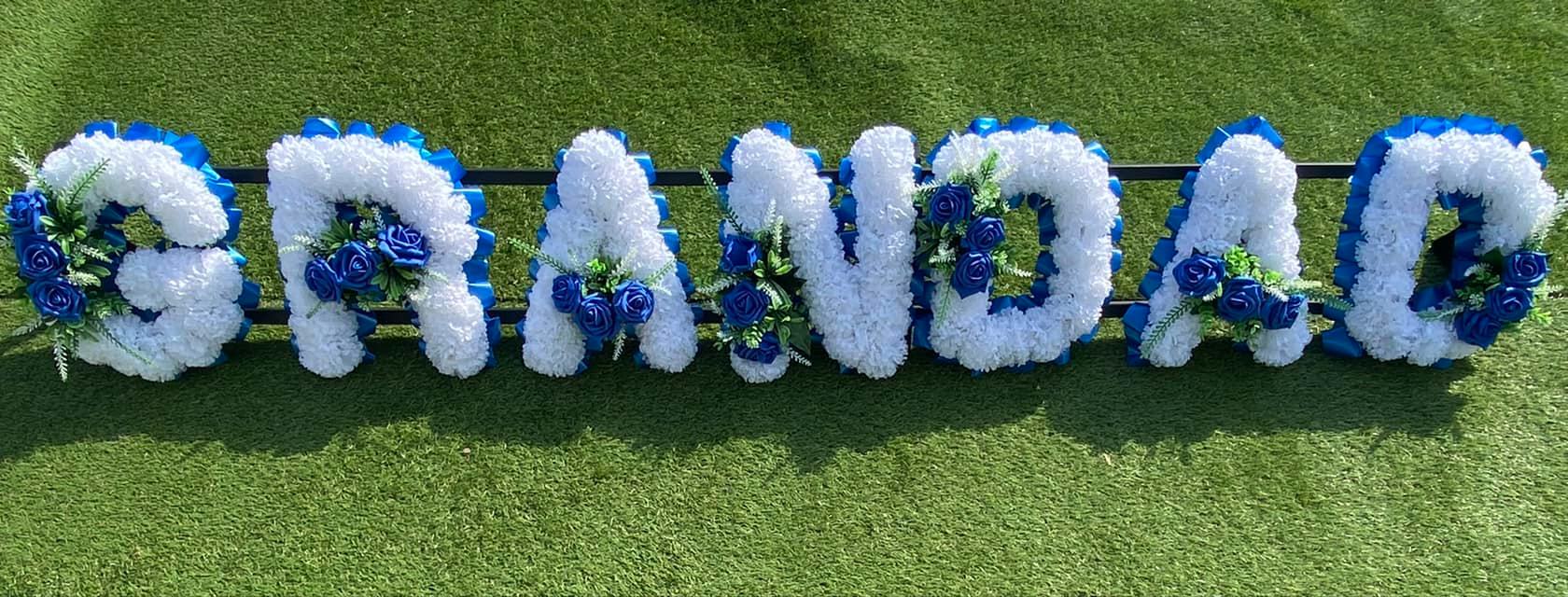 Funeral Flowers Sevenoaks guide with heart-shaped silk memorial wreath at a cemetery gate