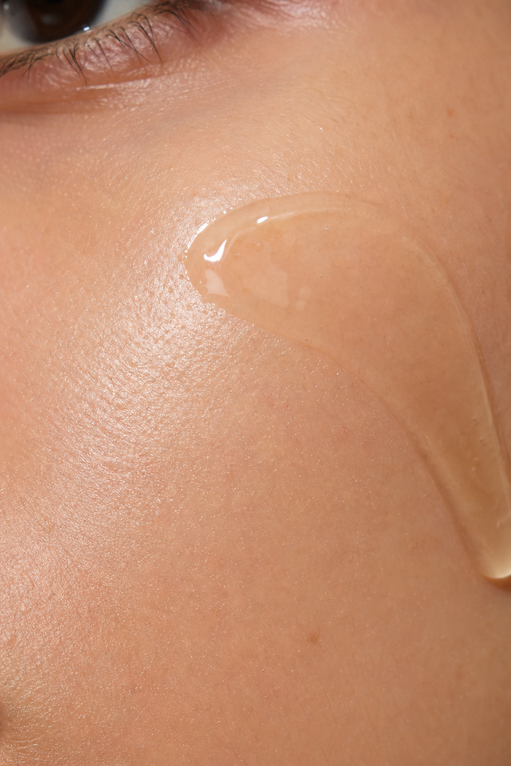 A realistic macro shot of a drop of serum spreading over smooth facial skin, highlighting the clarity and poreβrefining effect of niacinamide. Alt: Clarifying serum refining pores