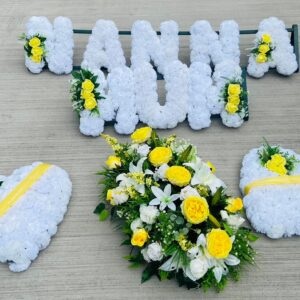 A realistic silk cross flower arrangement on a wooden stand, soft lighting, alt=