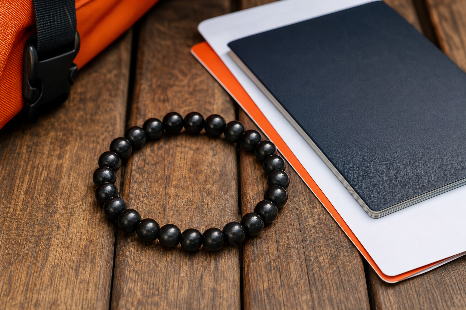 A realistic closeâup of a black shungite bracelet on a wooden travel table, with a passport and boarding pass beside it,