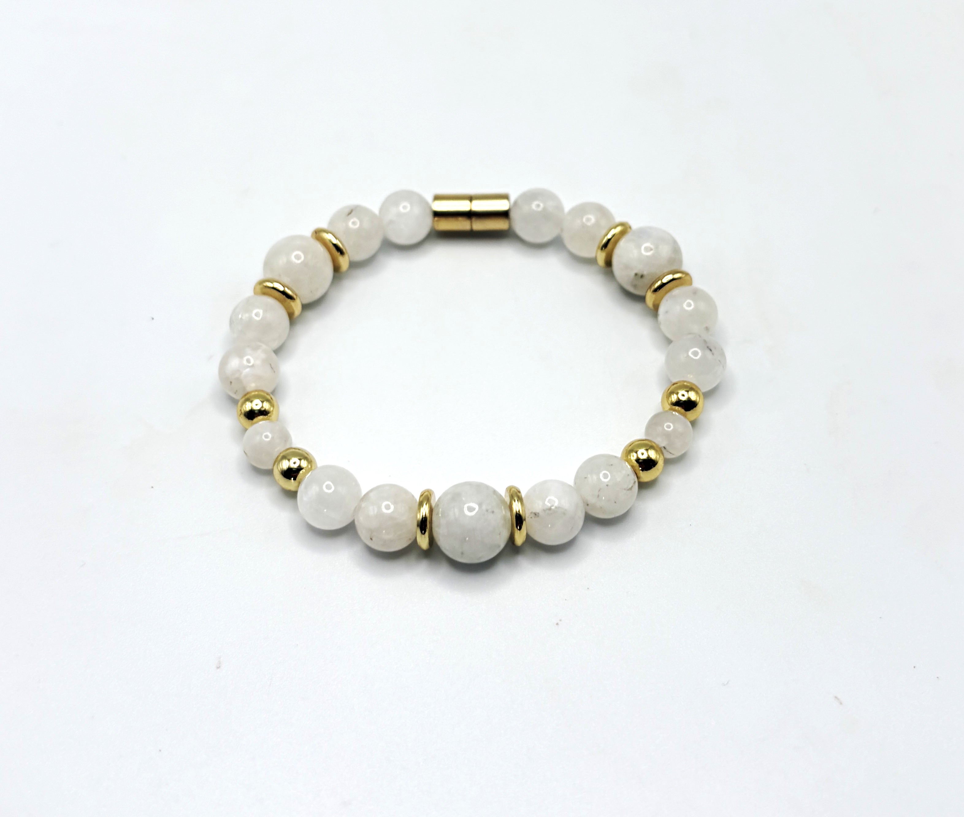 A photorealistic scene of a moonstone bracelet lying on an airline seat tray, soft cabin lighting, a window showing a ni