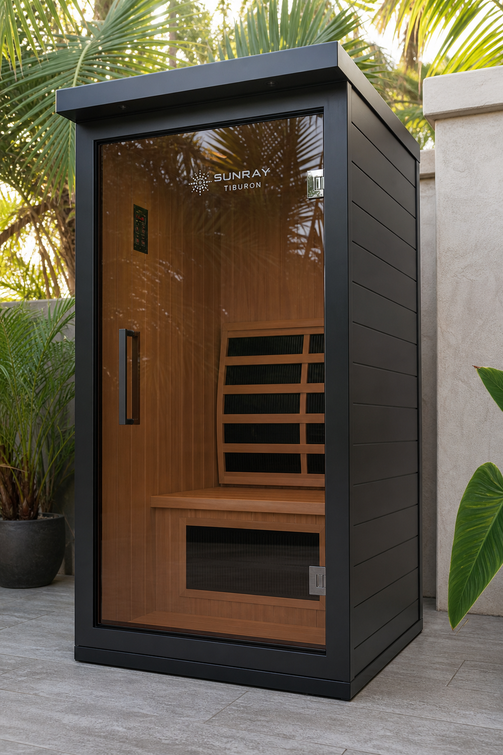 A photorealistic image of a modern outdoor infrared sauna with a black aluminum exterior and tinted glass door, placed on a patio with tropical plants. Alt: Sunray Tiburon 2-person infrared sauna outdoor.