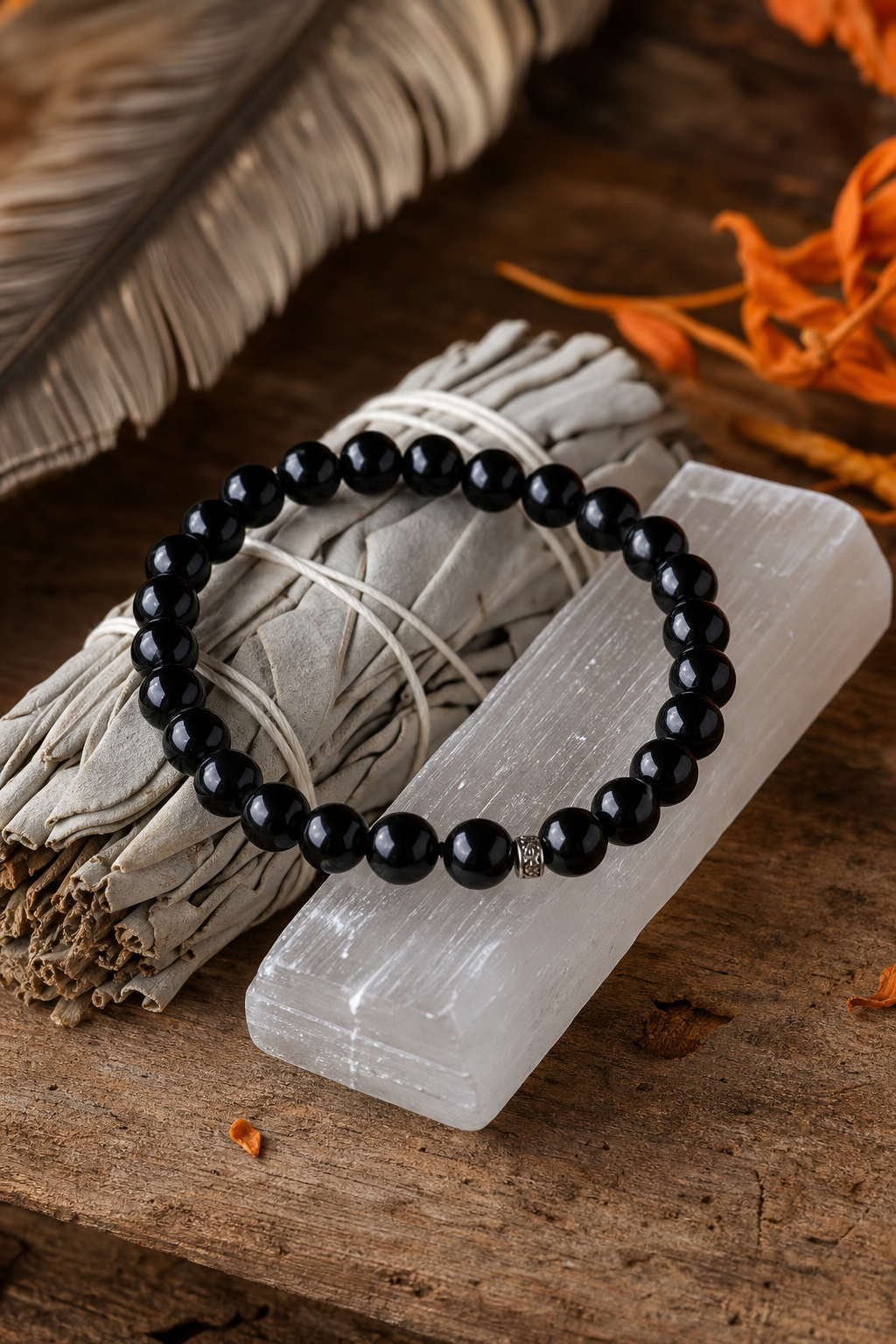 A photorealistic still life of a black obsidian bracelet lying on a piece of white sage and a selenite stick, with soft natural lighting and a calm, minimalist aesthetic. Alt: Black obsidian crystal bracelet with sage for cleansing