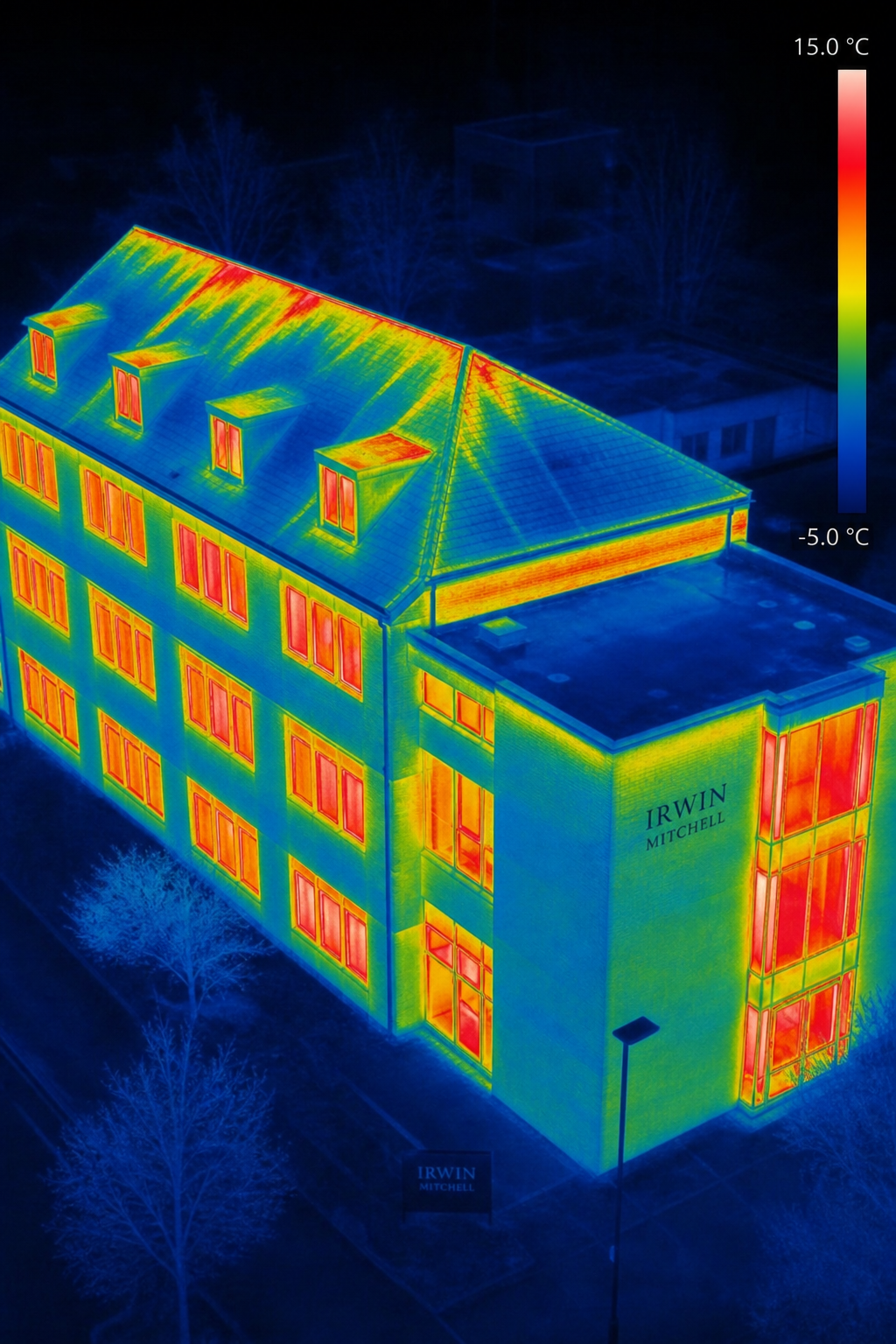 A thermal image of a commercial building showing heat loss through windows and roof, with color gradient from red (hot) to blue (cold). Alt: Thermal imaging drone survey of a commercial building detecting heat loss.