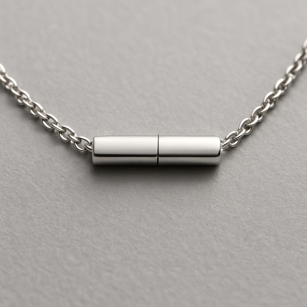 A close‑up of a modern invisible bar clasp on a thin silver chain, showing a seamless connection. Alt: Invisible bar clasp necklace design