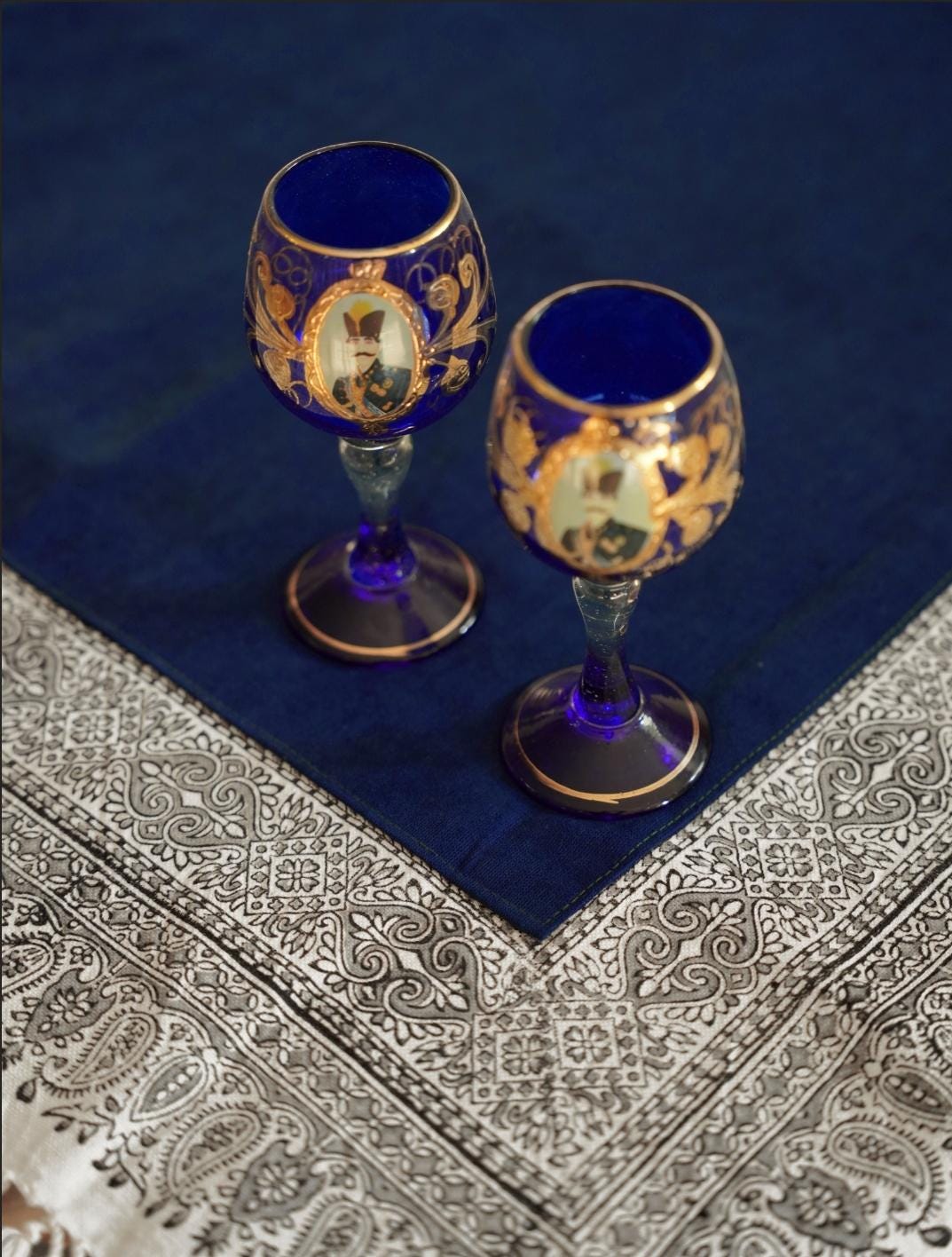 Persian ghalamkari tablecloth in indigo block print on a wooden dining table.