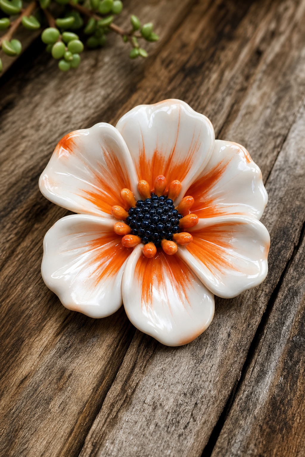 A bright studio shot of a finished polymer clay flower sitting on a wooden surface, light reflecting off a polished glaze, alt=