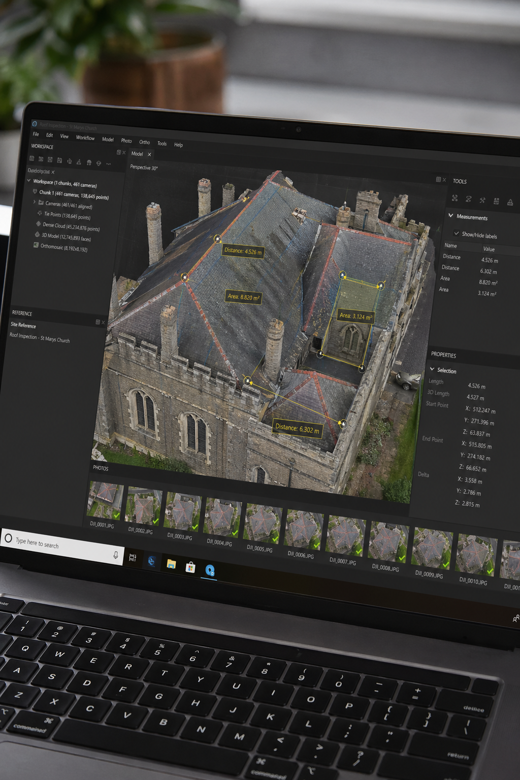 A high-angle shot of a laptop screen showing a photogrammetry software interface with a 3D roof model, overlaid with measurement tools and annotations. Alt: Drone roof inspection data processing software with 3D model.