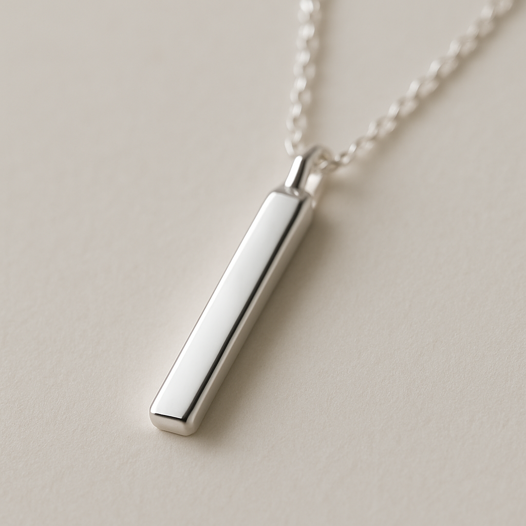 A close‑up of a sleek sterling silver bar pendant hanging on a delicate chain, soft light reflecting off the polished surface. Alt: classic sterling silver bar pendant necklace timeless elegance