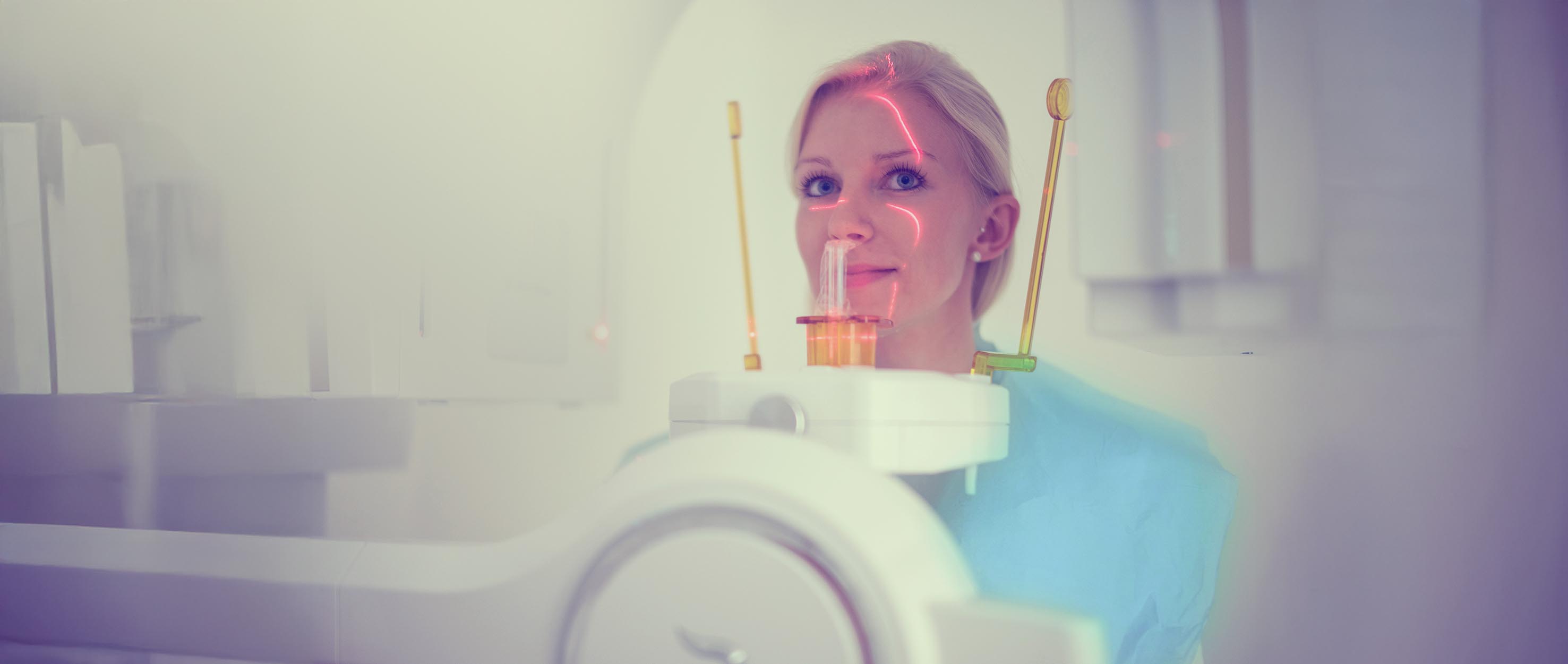 Person an einem dentalen Aufnahmegerät mit Kinnstütze und roter Positionierungslinie.