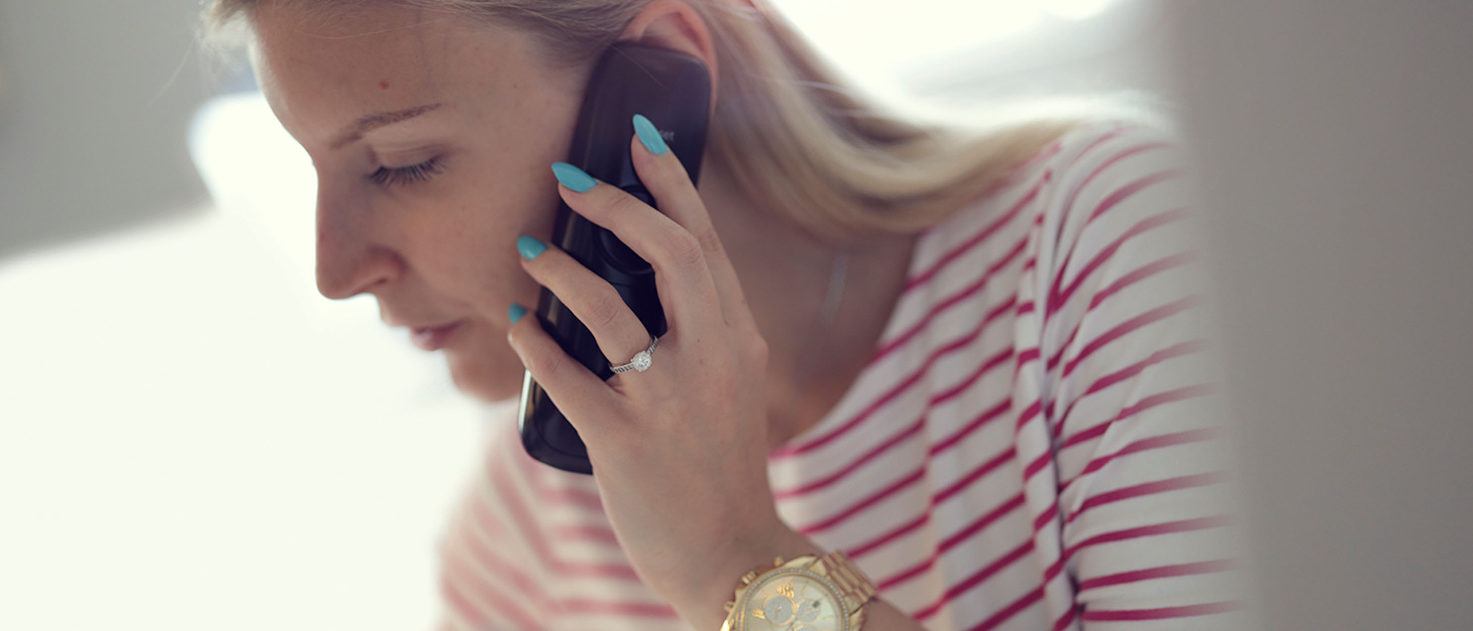 Person mit einem Mobiltelefon am Ohr.